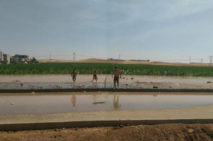 Sıcaklardan bunalan çocuklar çamurlu suda yüzdü